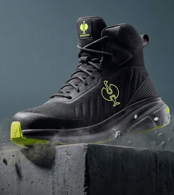 Schwarzer hoher Schuh mit gelben Details auf einem Betonblock.