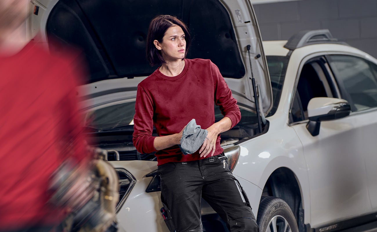 Frau in Autowerkstatt trägt neuen e.s. industry Pullover