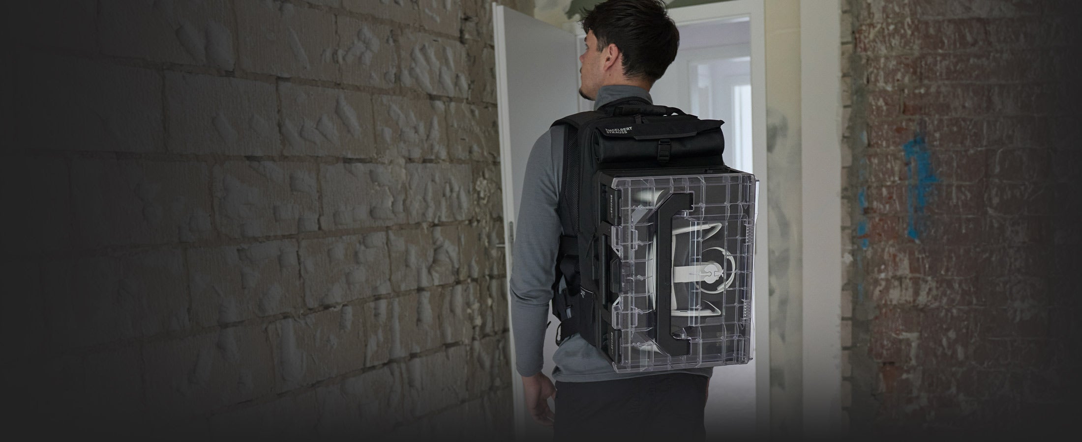 Ein junger Handwerker trägt den STRAUSSbox Rucksack an den die STRAUSSbox XR Edition gekoppelt ist.