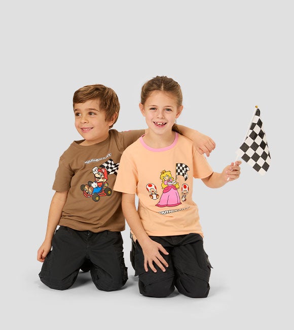 Junge und Mädchen tragen die neuen MarioKart Tshirts