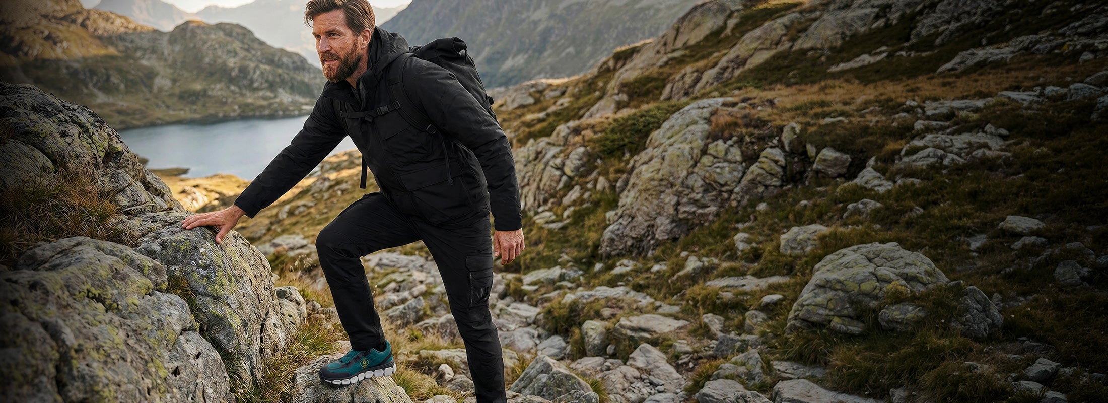 KI-generiert / modifiziert - Mann mit Strauss-Rucksack trägt e.s.Trail Produkte und klettert über Felsen in bergiger Landschaft neben einem See.