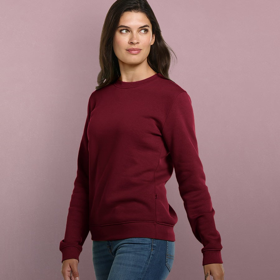 Vrouw draagt sweatshirt in de kleur bordeaux.