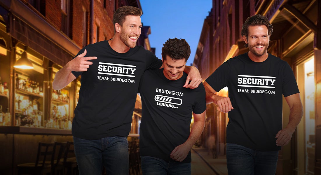 Drie mannen in e.s.basics-shirts met de opdrukken “Securityteam Bruidegom” en “Bruidegom aan het laden” in de avond