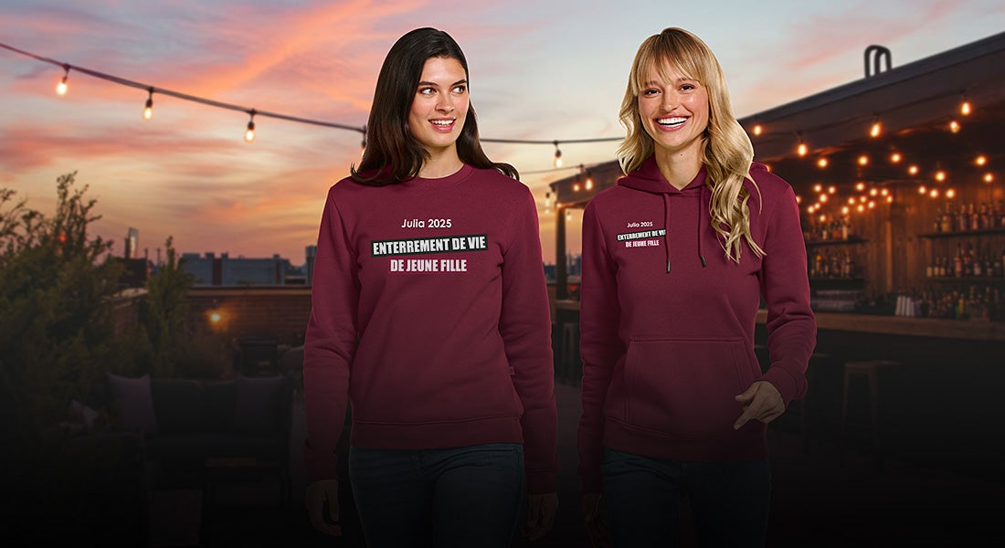 Deux femmes en sweat-shirts e.s.basics avec l’inscription « Enterrement de vie de jeune fille » en soirée