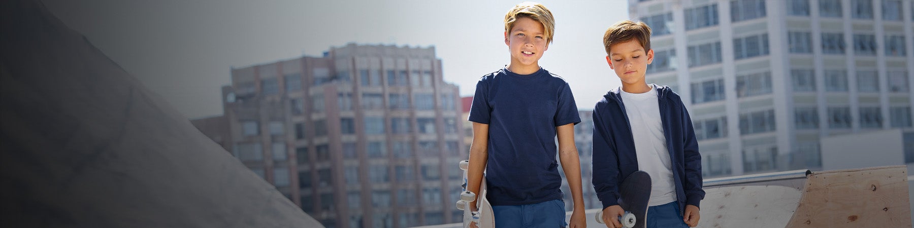 Twee kinderen dragen shirts en truien van Strauss