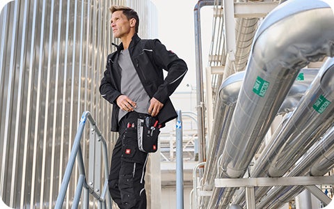Ein Mann steht seitlich auf einer Treppe