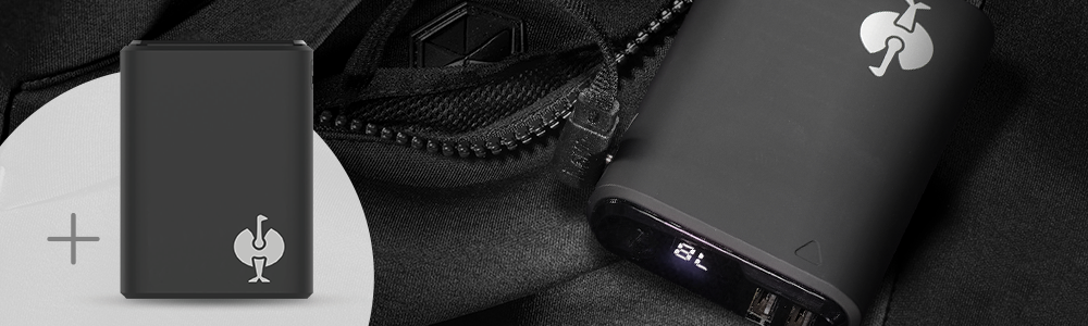 Eine Powerbank mit digitaler Ladeanzeige liegt neben dem Reißverschluss der e.s. Heizweste climafoam HW25.