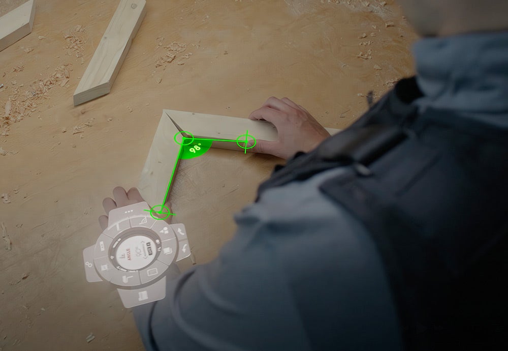 Avec la Toolbox XR au poignet, un artisan mesure l'angle entre deux poutres en bois.