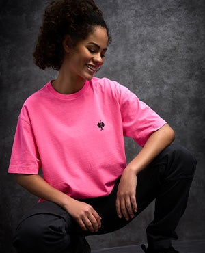Une femme porte un t-shirt vintage rose néon.