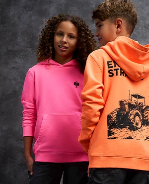 Un enfant vêtu d'un pull à capuche vintage rose néon et un enfant vu de dos vêtu d'un pull à capuche vintage orange néon. Au dos, on peut voir un imprimé sympa avec l'inscription engelbert strauss.