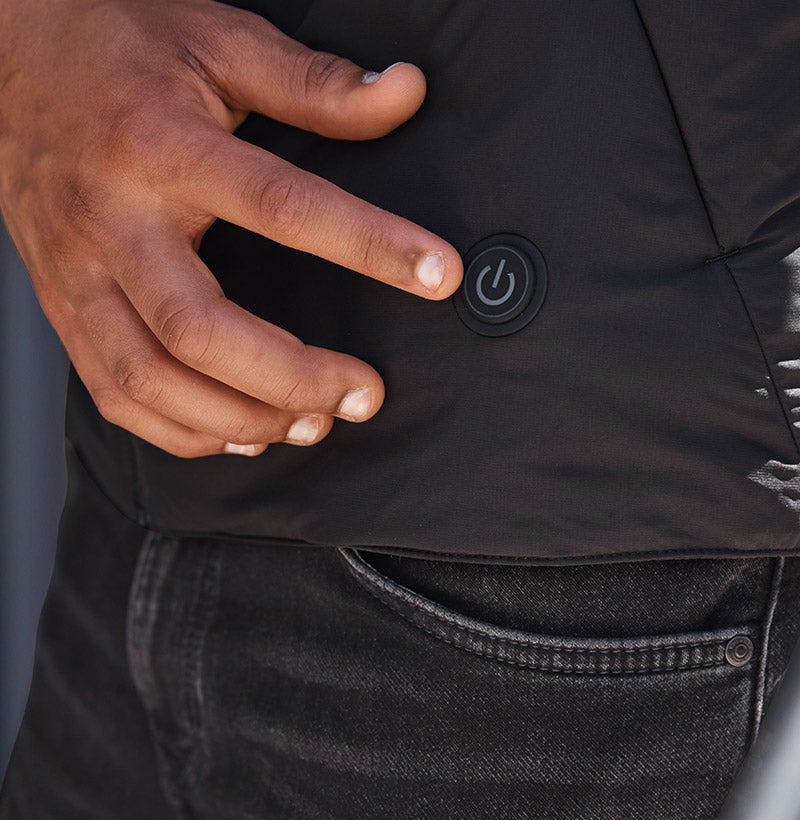 Person presses button on heated vest