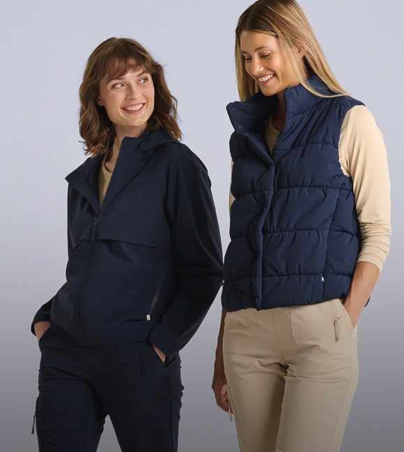 Deux femmes portent le gilet et la veste fonctionnelle e.s.avida en bleu foncé.