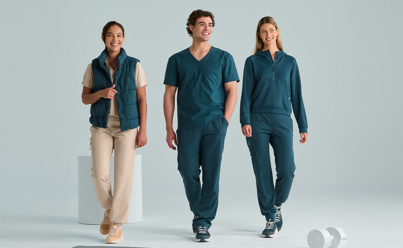 A team of two women and a man wearing the new e.s.avida carewear collection in sea blue.