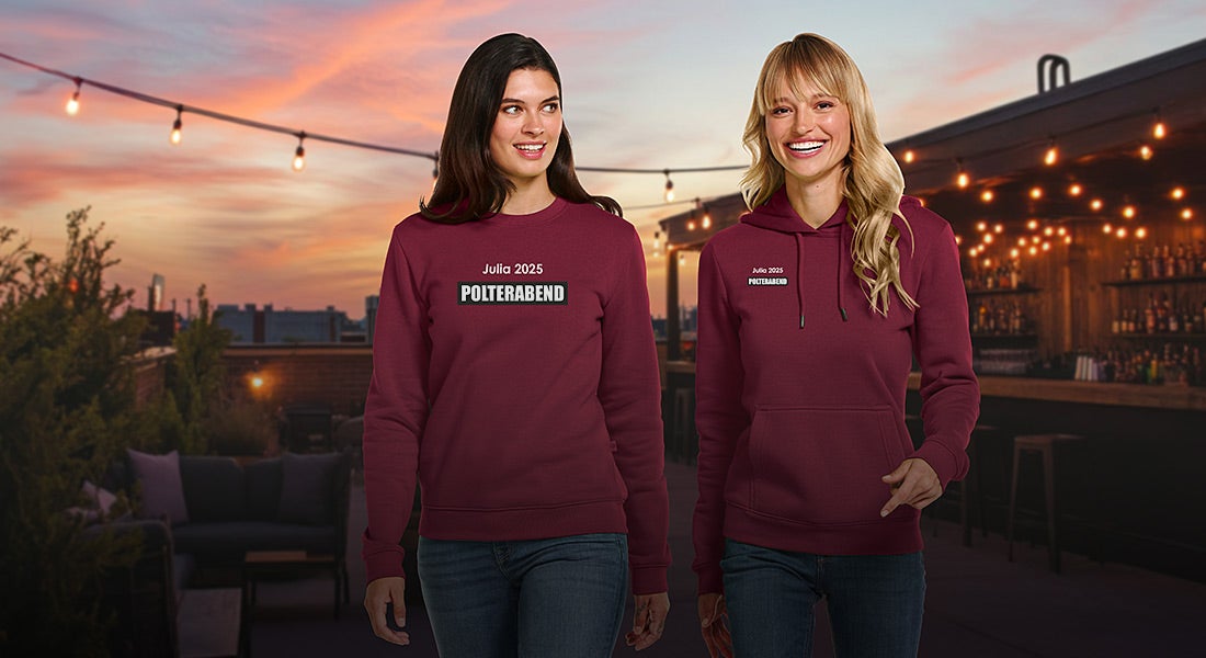 To damer i e.s.basics-trojer med trykket „Polterabend“ om aftenen