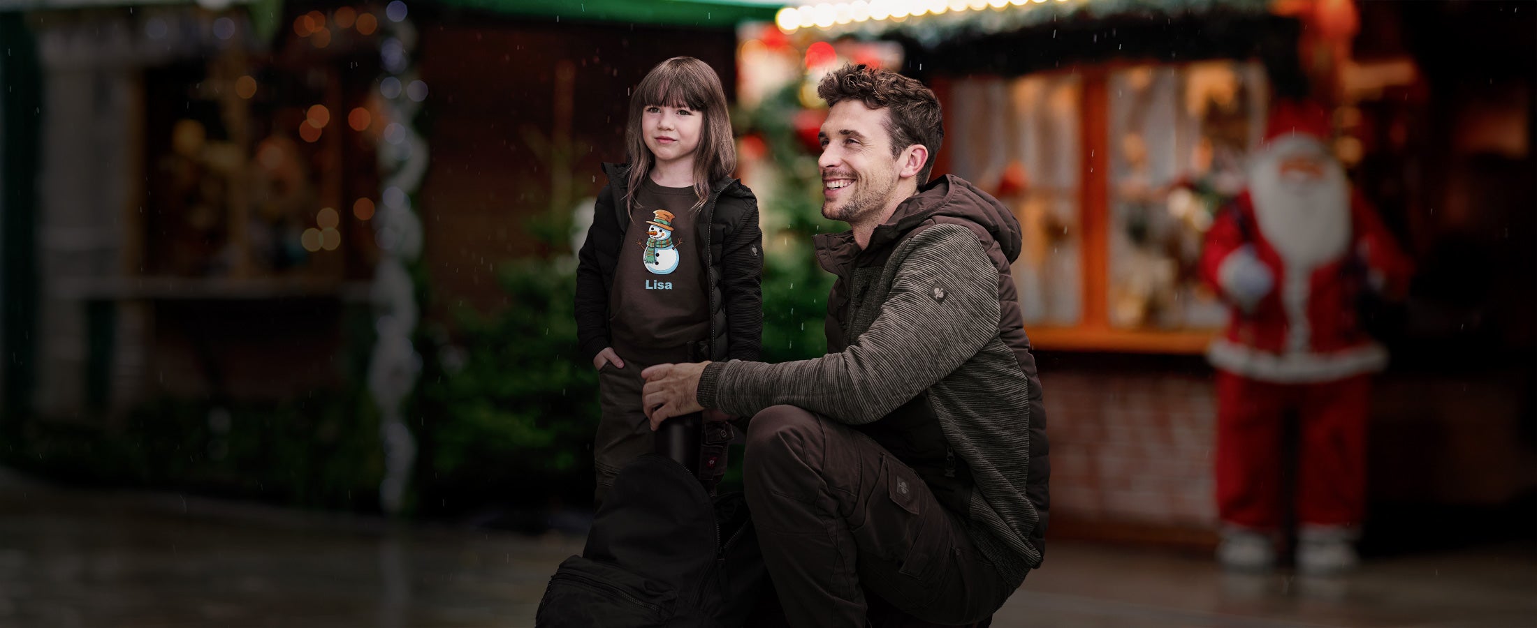 A child and a man at the Christmas market wearing clothes by Strauss.
