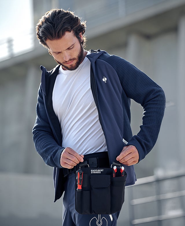 Man detaches tool pouch from tool belt