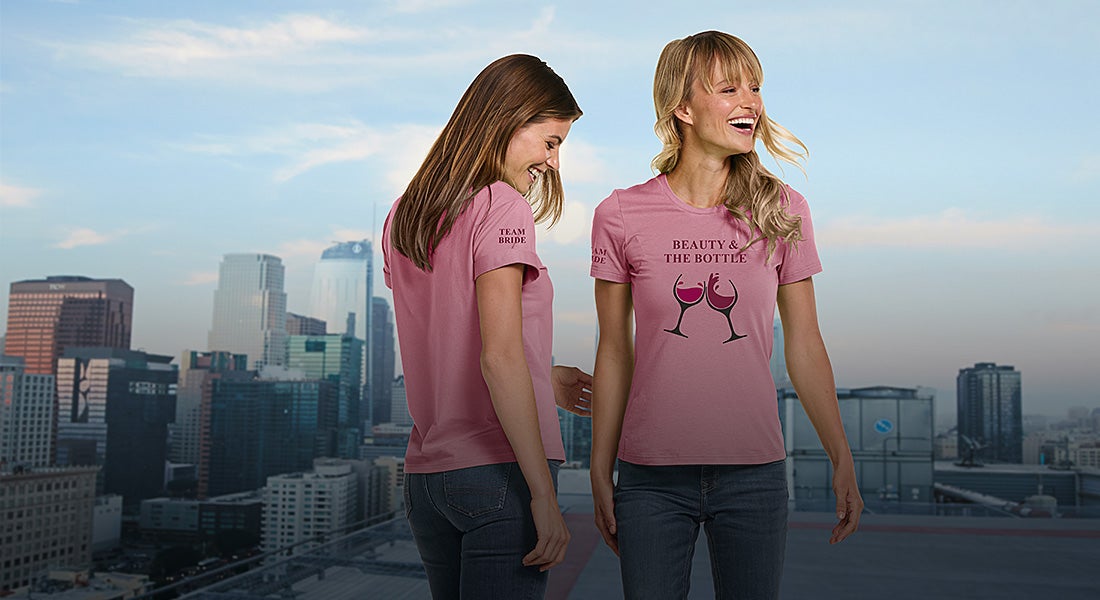 Two ladies wearing e.s.basics shirts with the prints “Team Bride” and “Beauty and the Bottle”