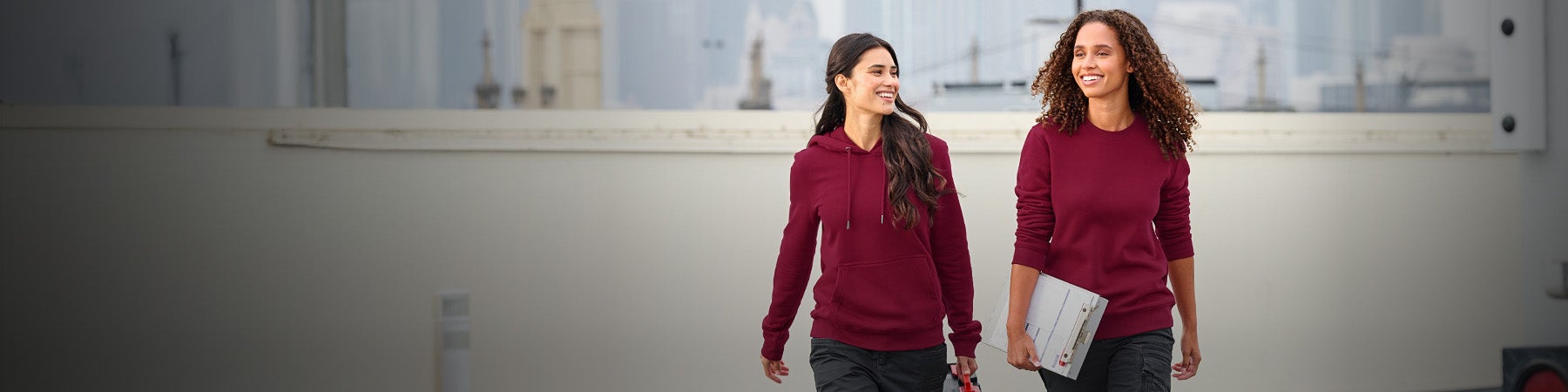Two women wearing sweatshirts and hoodies by Strauss