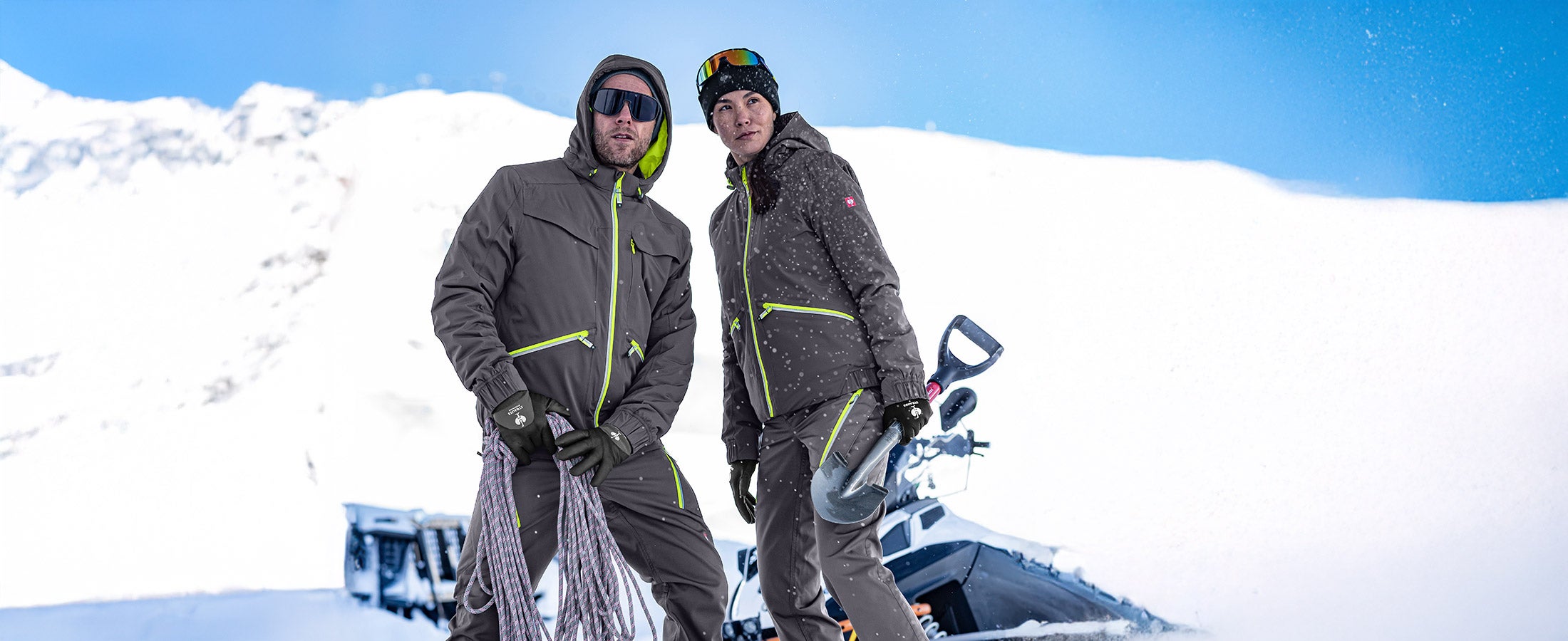 Man and woman wearing e.s.ambition winter jackets in graphite/blue