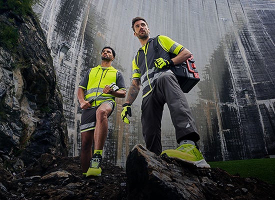 Two men wearing e.s.ambition collection in anthracite/high-vis yellow