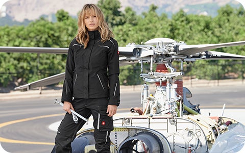 Eine Frau steht vor einem Helikopter