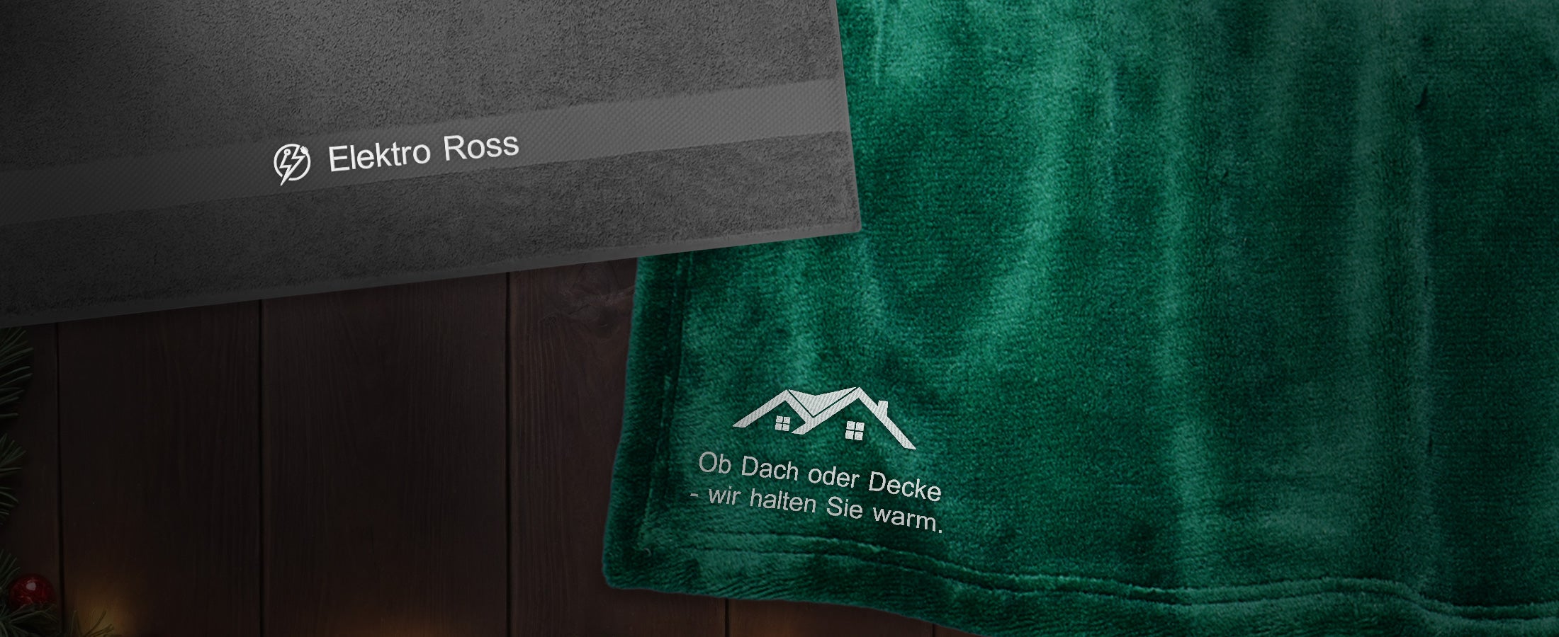 Ein Handtuch und eine Fleecedecke von Strauss liegen auf einem Holztisch.
