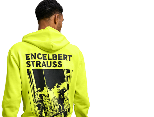 Ein Mann von hinten, der ein neongelbes Vintage-Shirt trägt. Auf dem Rücken ist ein cooler Print mit dem Schriftzug ‚engelbert strauss‘ zu sehen.