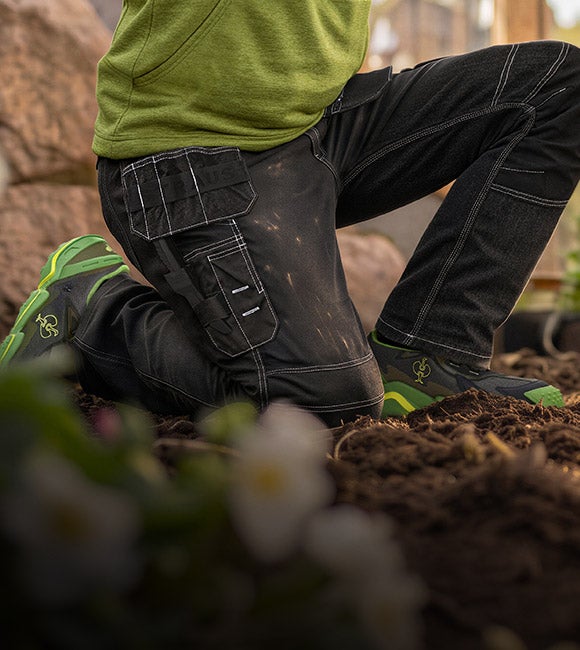 KI-generiert / modifiziert - Person kniet bei der Gartenarbeit auf Erde und trägt die POWERdenim Holster Jeans e.s.line.nordic.