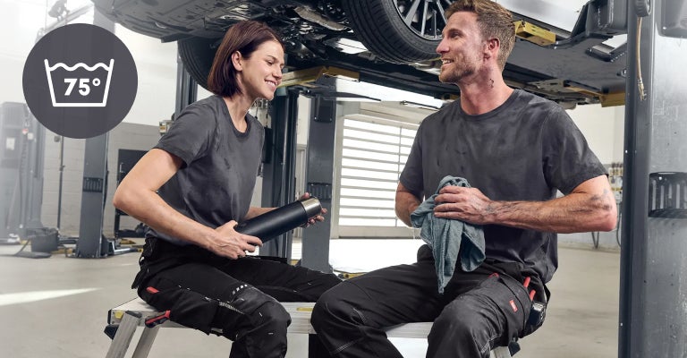 Een dame en heer werken in een autowerkplaats en dragen e.s. industry-shirts