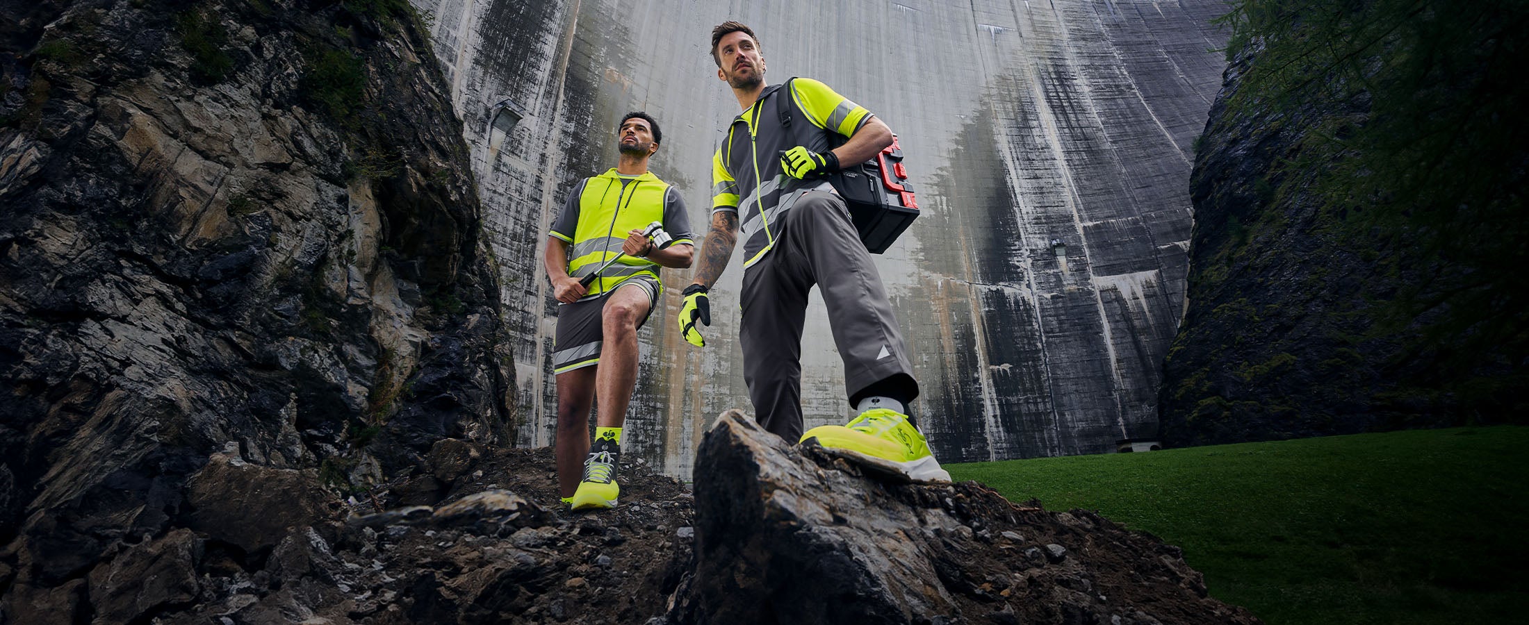 Twee heren dragen de e.s.ambition collectie in antraciet/signaalgeel