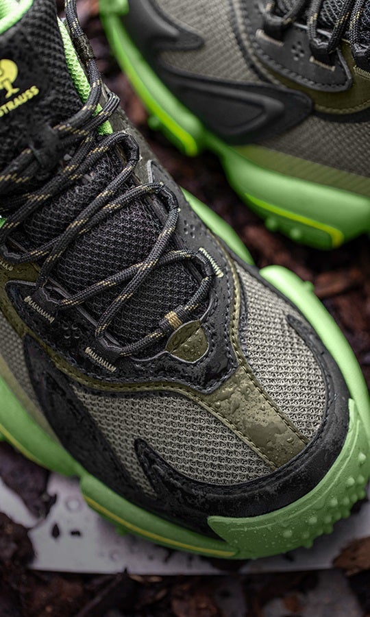 Close-up van S7S veiligheidsschoenen e.s. Peoria low in camouflagegroen/zeegroen op een aardse achtergrond