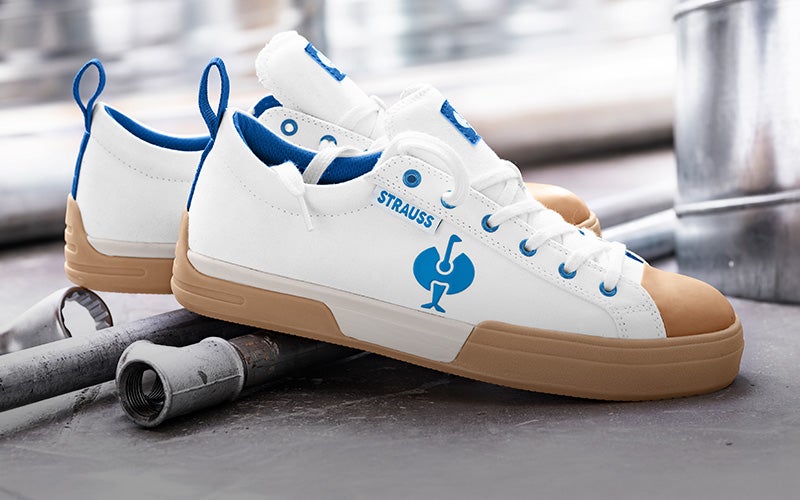 Casual foto van S1 veiligheidsschoenen e.s. Yatala low in wit/gentiaanblauw op een betonnen achtergrond met schroevendraaiers