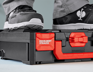 Person standing on closed STRAUSSbox, showing the boxes’ high load capacity