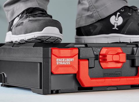Person standing on closed STRAUSSbox, showing the boxes’ high load capacity