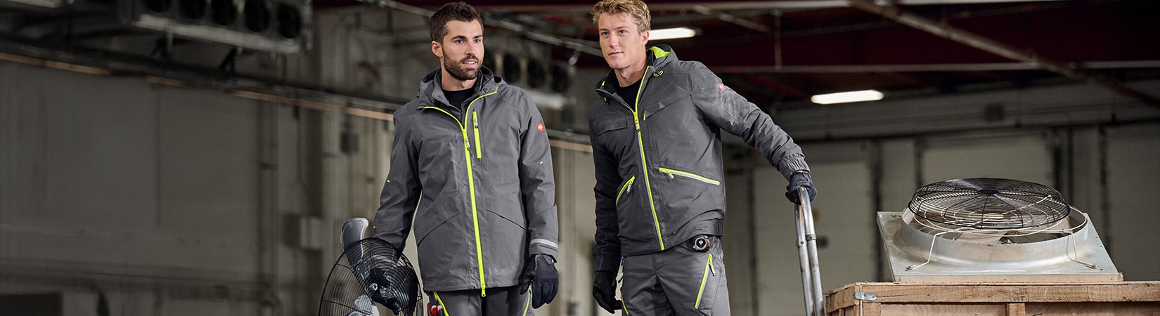 Two men wearing e.s.ambition collection in anthracite/high-vis yellow