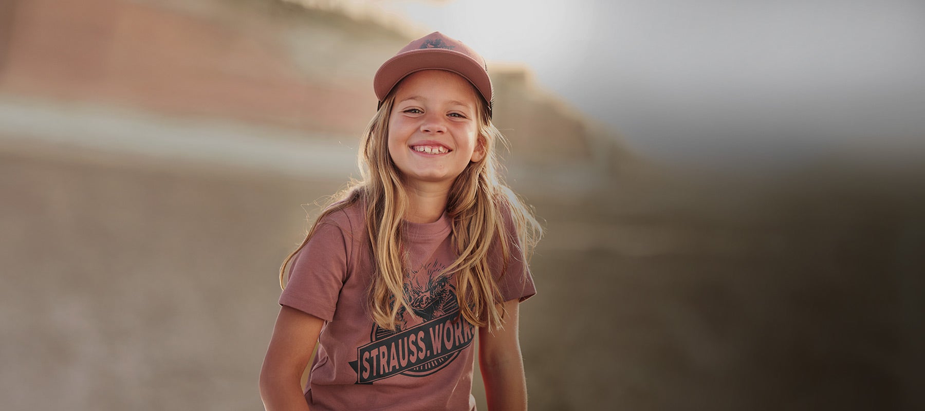 Child wearing a T-shirt with Strauss print in oxide red