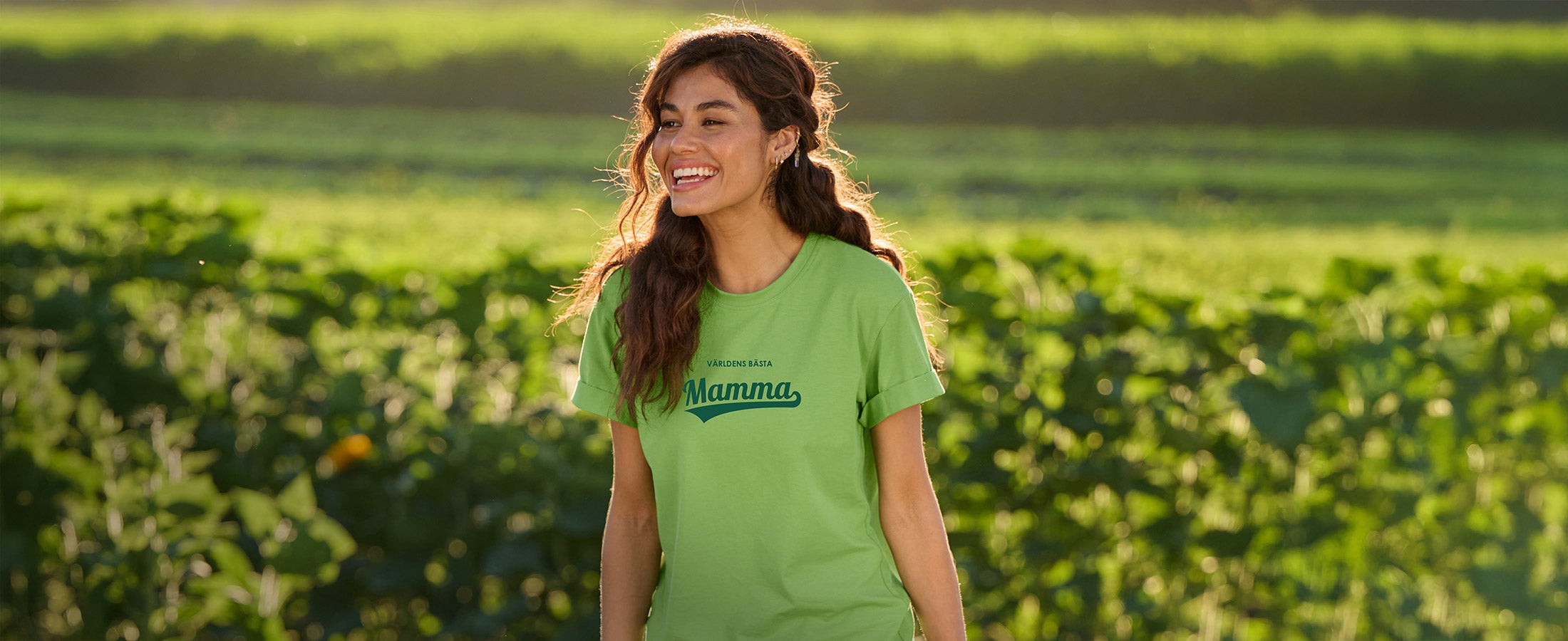 En kvinna i en grön e.s. t-shirt med trycket – Världens bästa mamma
