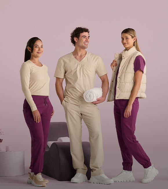 Ett team bestående av två kvinnor och en man bär den nya Carewear-kollektionen e.s.avida i jurabeige och rödviolett.