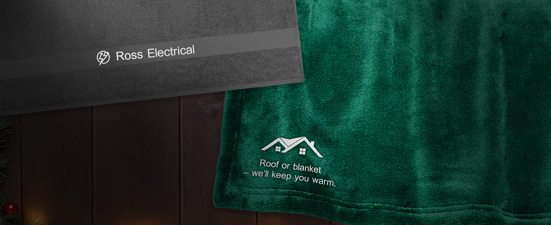 A towel and a fleece blanket from Strauss lying on a wooden table.
