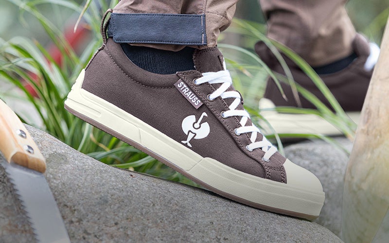 S1 safety shoes e.s. Yatala low in chestnut worn by a person in a stony and green environment