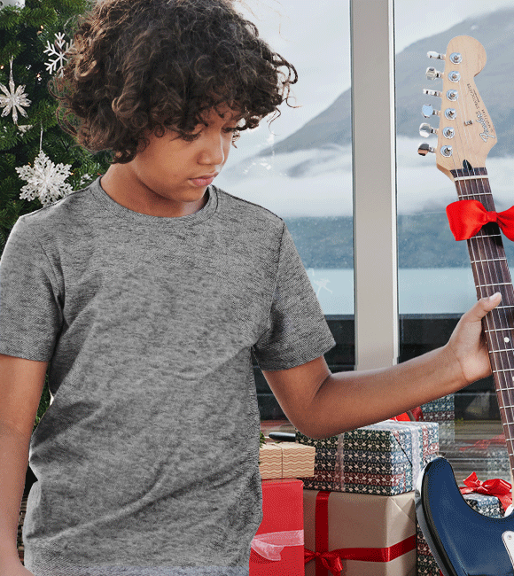 Dieťa rozbaľuje darčeky a má na sebe oblečenie značky Strauss.