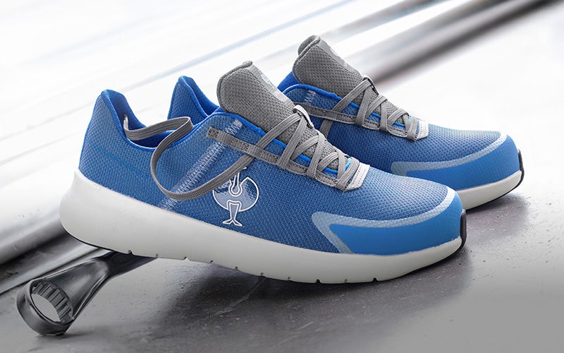 Casual image of SB safety shoes e.s. Taupo low in gentian blue/silver on a concrete background with screwdriver